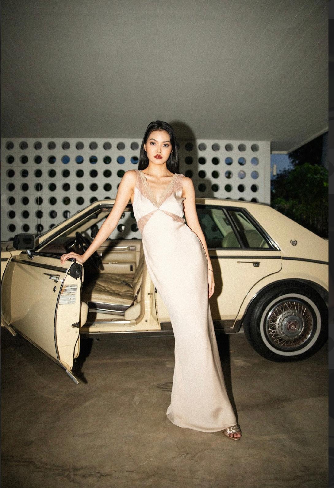 Champagne satin evening gown with blush lace trim, styled by Olga, worn beside a vintage car at night